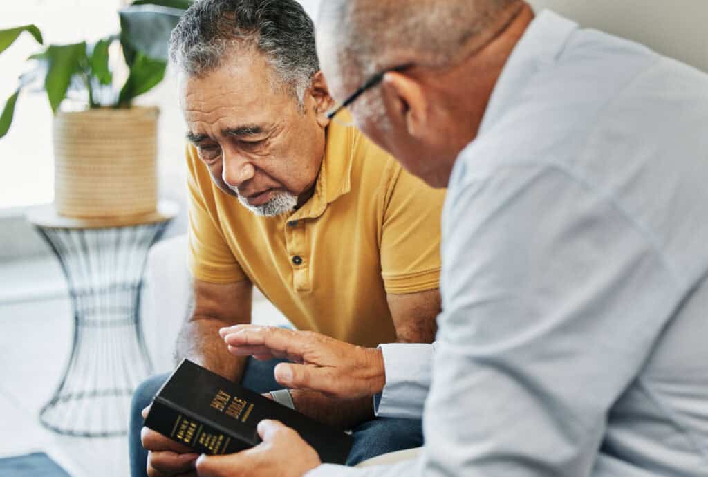 Men, home and bible with counselling on faith, worship and prayer with pastor, church or christ. Elderly men, diversity and spiritual guidance for grief with loss and depression with hope in jesus.